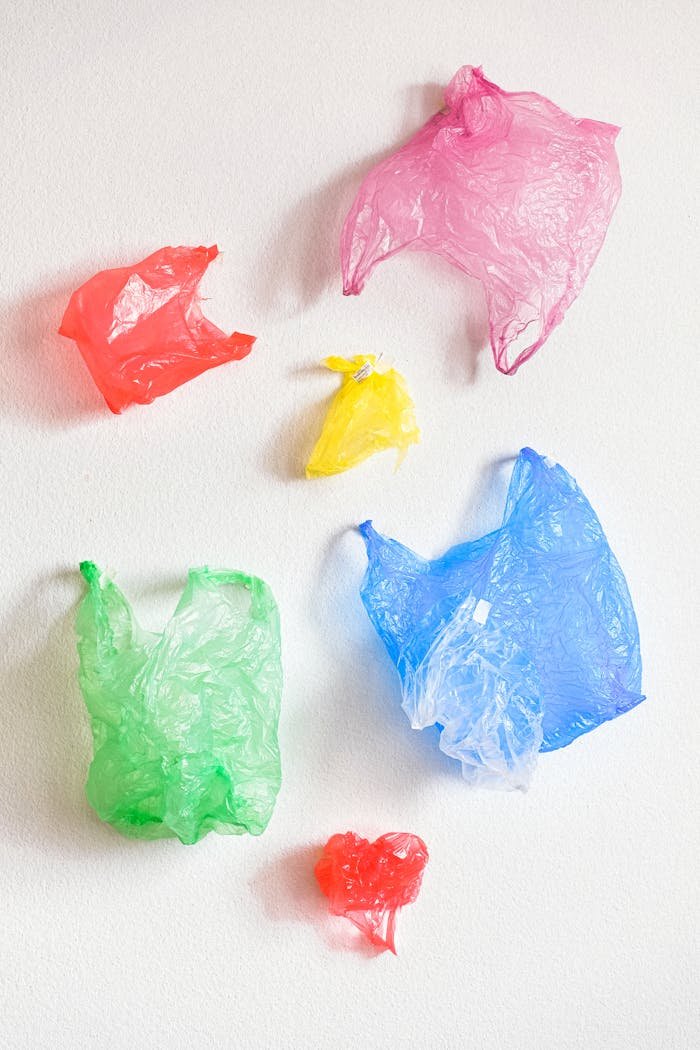 Artistic arrangement of colored plastic bags emphasizing recycling and pollution awareness.
